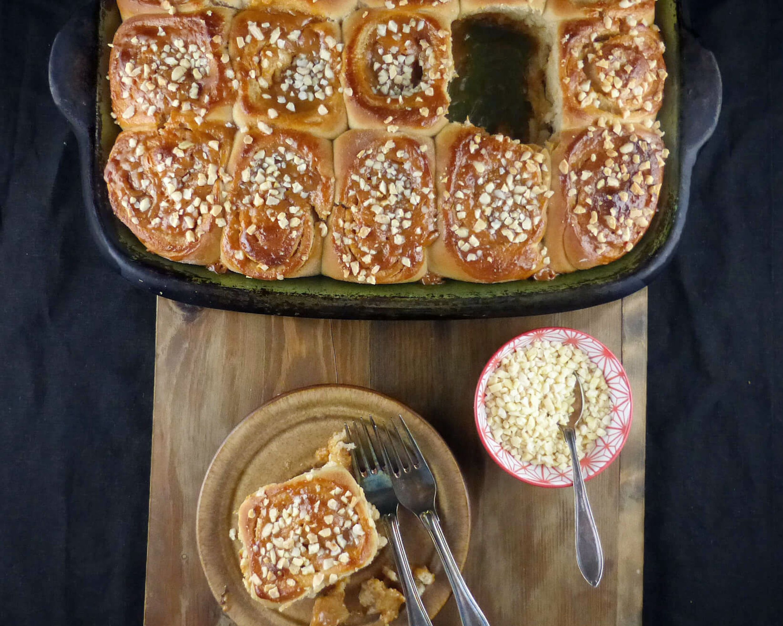 overhead shot of a tray of sticky buns with one bun in front.