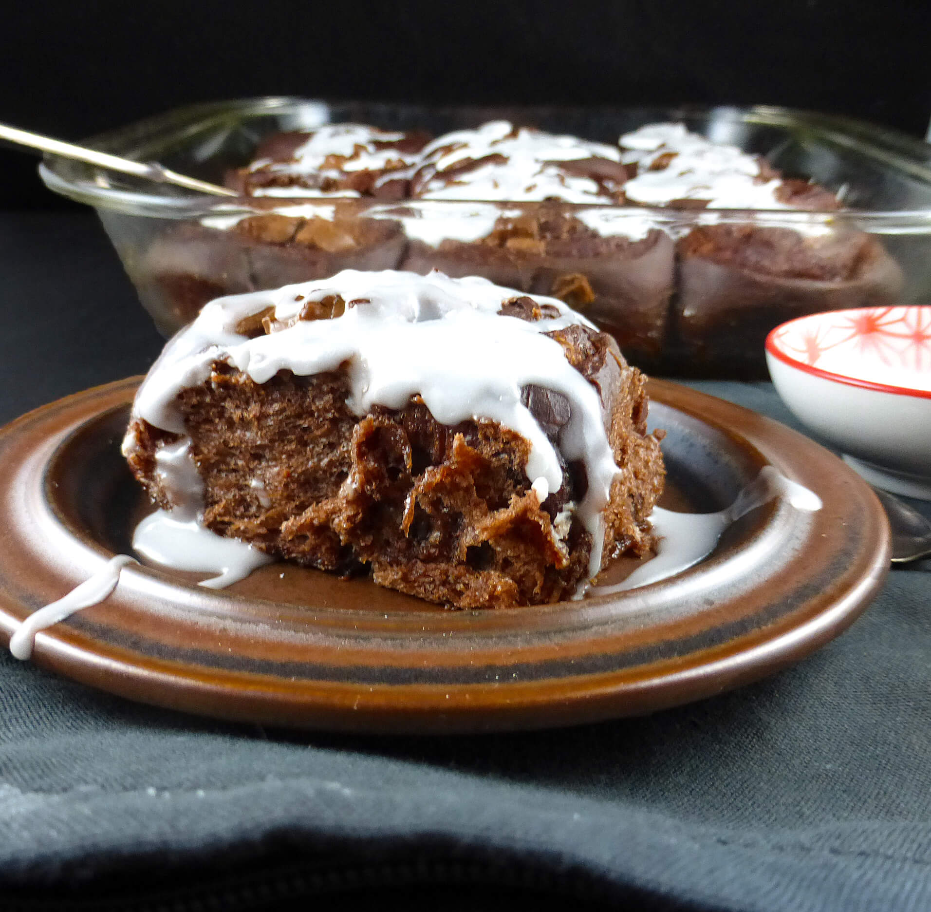 a close up of a chocolate cinnamon bun with white icing