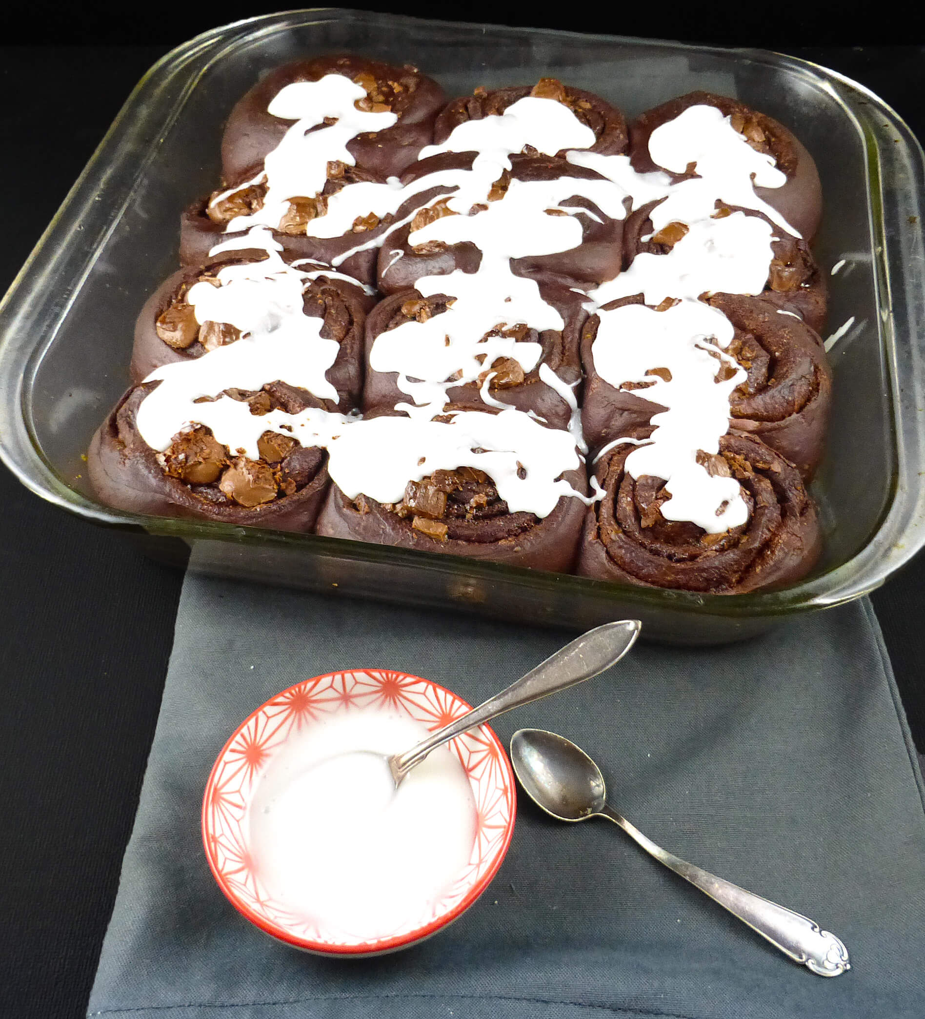 a picture of chocolate cinnamon buns with a white frosting