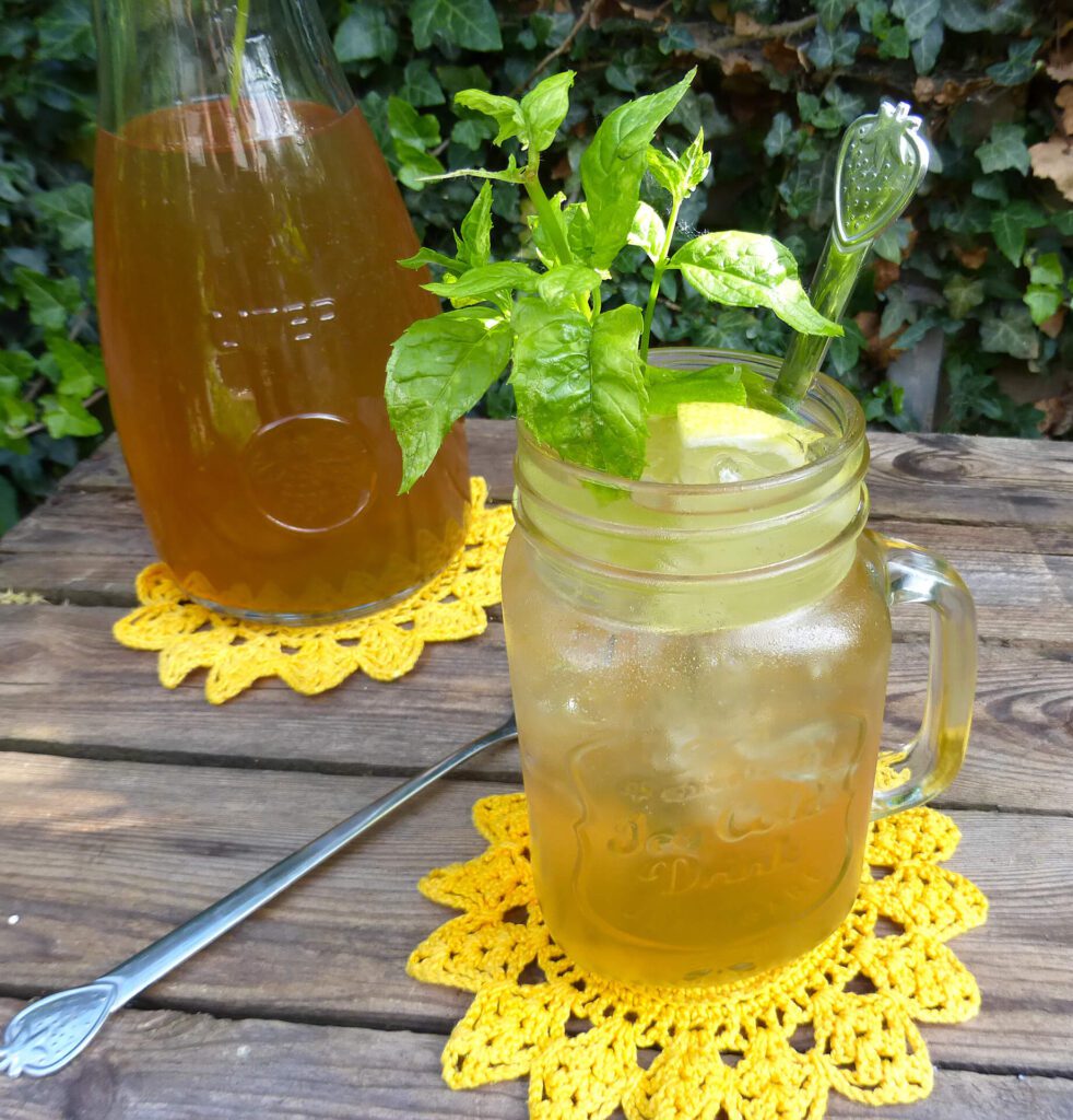 picture of a glass filled with elderflower cordial garnished with mint and lemons