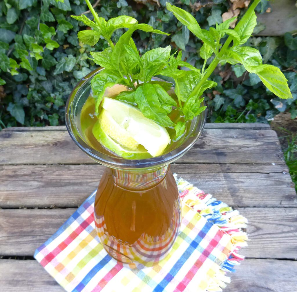 picture of a pitcher filled with elderflower cordial garnished with mint and lemons