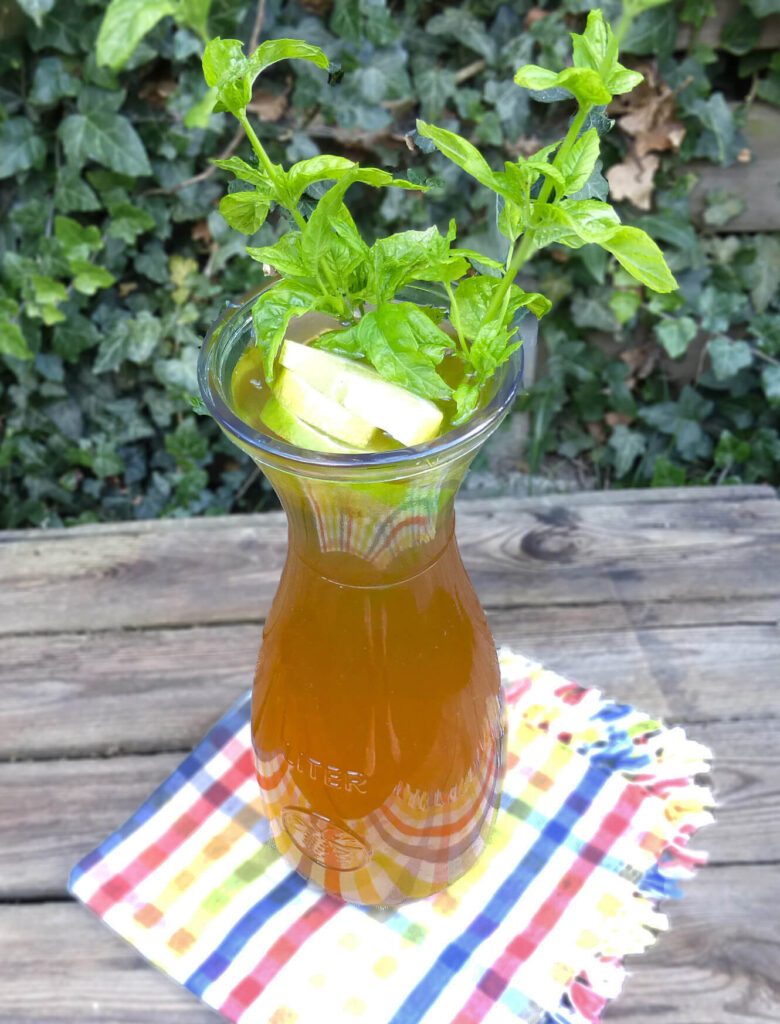 picture of a pitcher filled with elderflower cordial garnished with mint and lemons