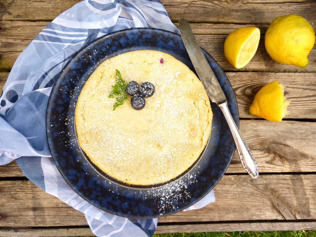 picture of a lemon kladdkaka on a blue plate with a knife