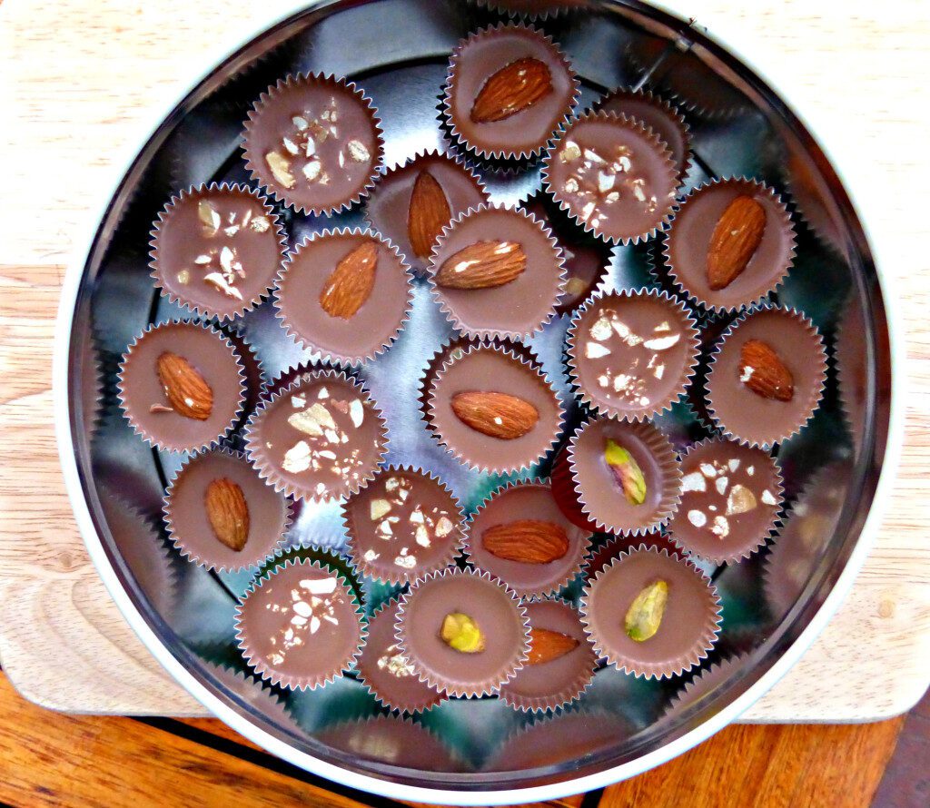 chocolates in a tin topped with various different nuts