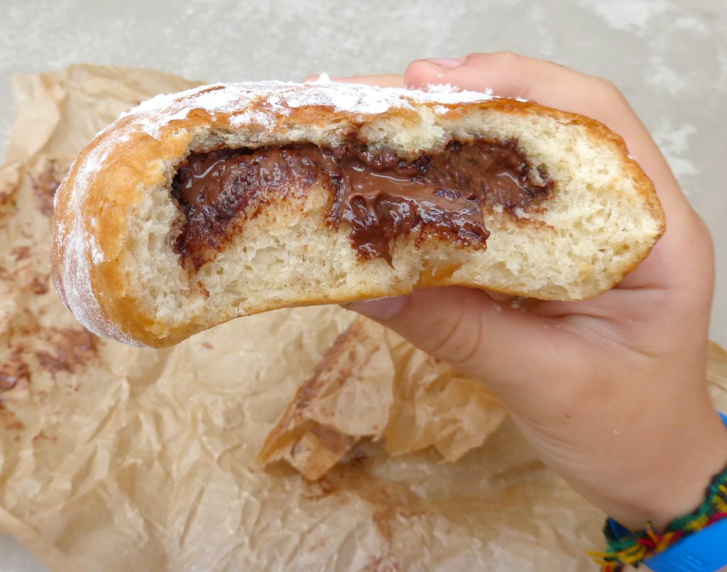 a Nutella doughnut with a huge bite taken out of it