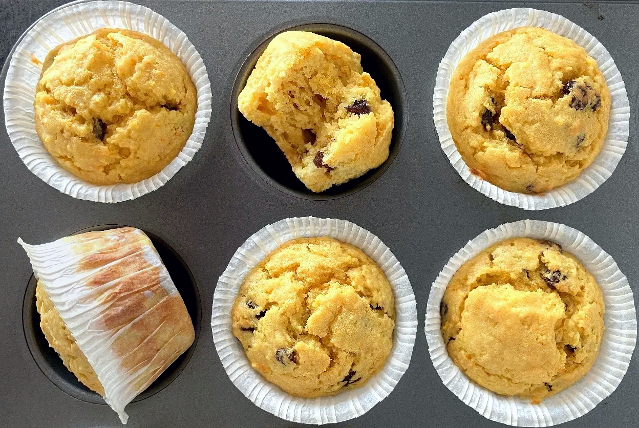 whole orange muffins in paper cases in a metal muffin tray