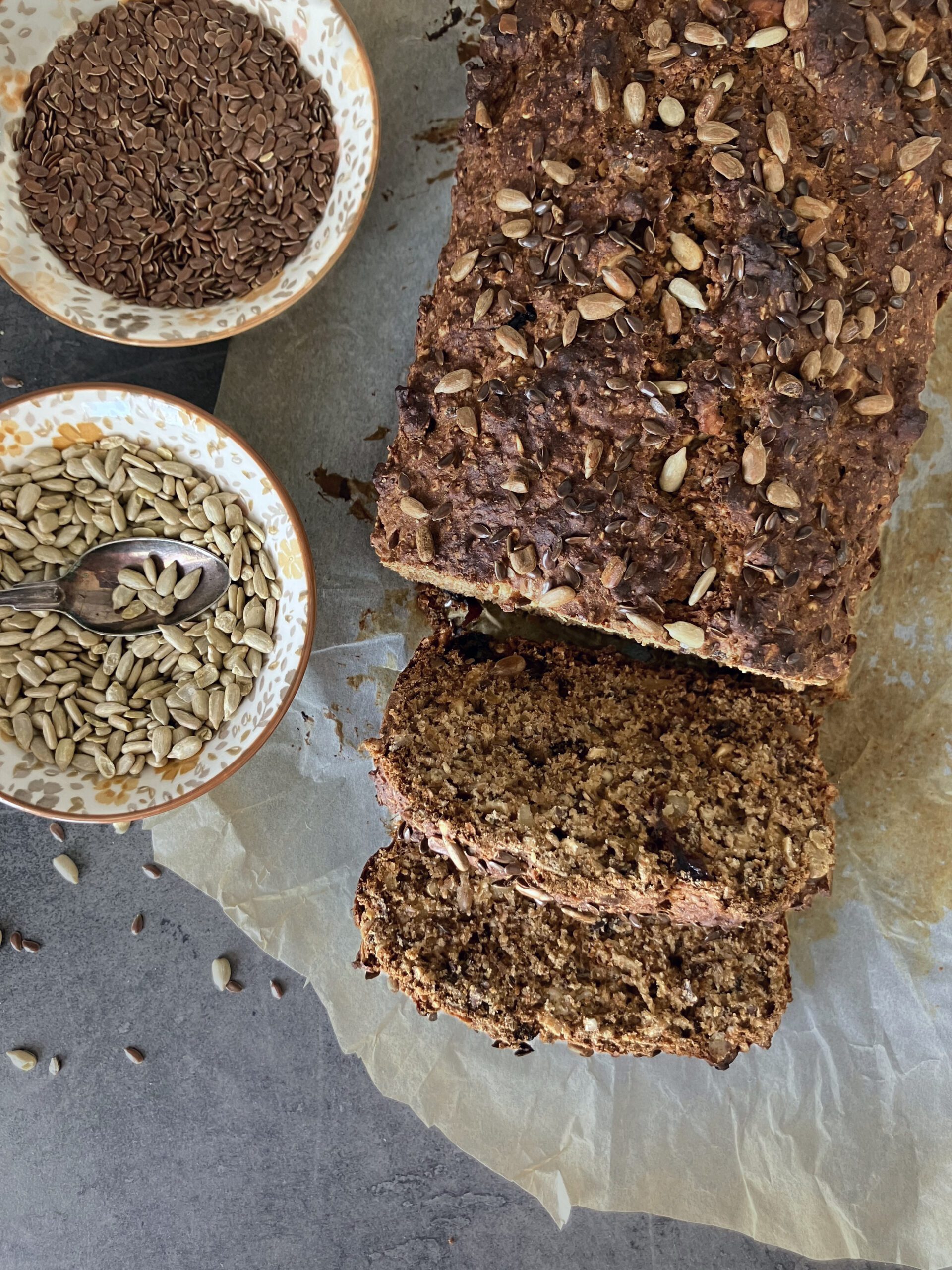 overhead shot of swedish rye bread with two bowls of seeds by the side