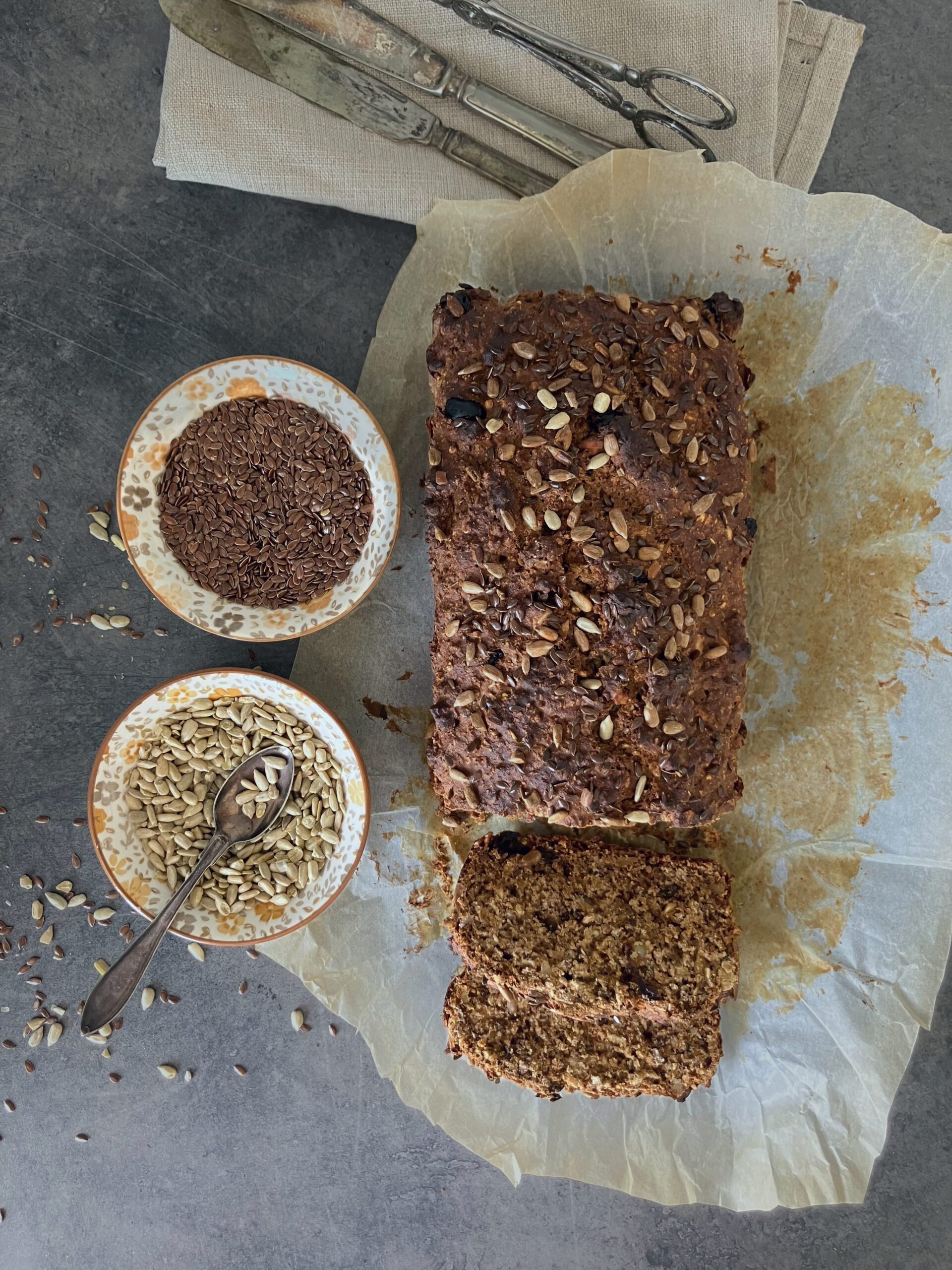 overhead shot of swedish rye bread with two bowls of seeds by the side