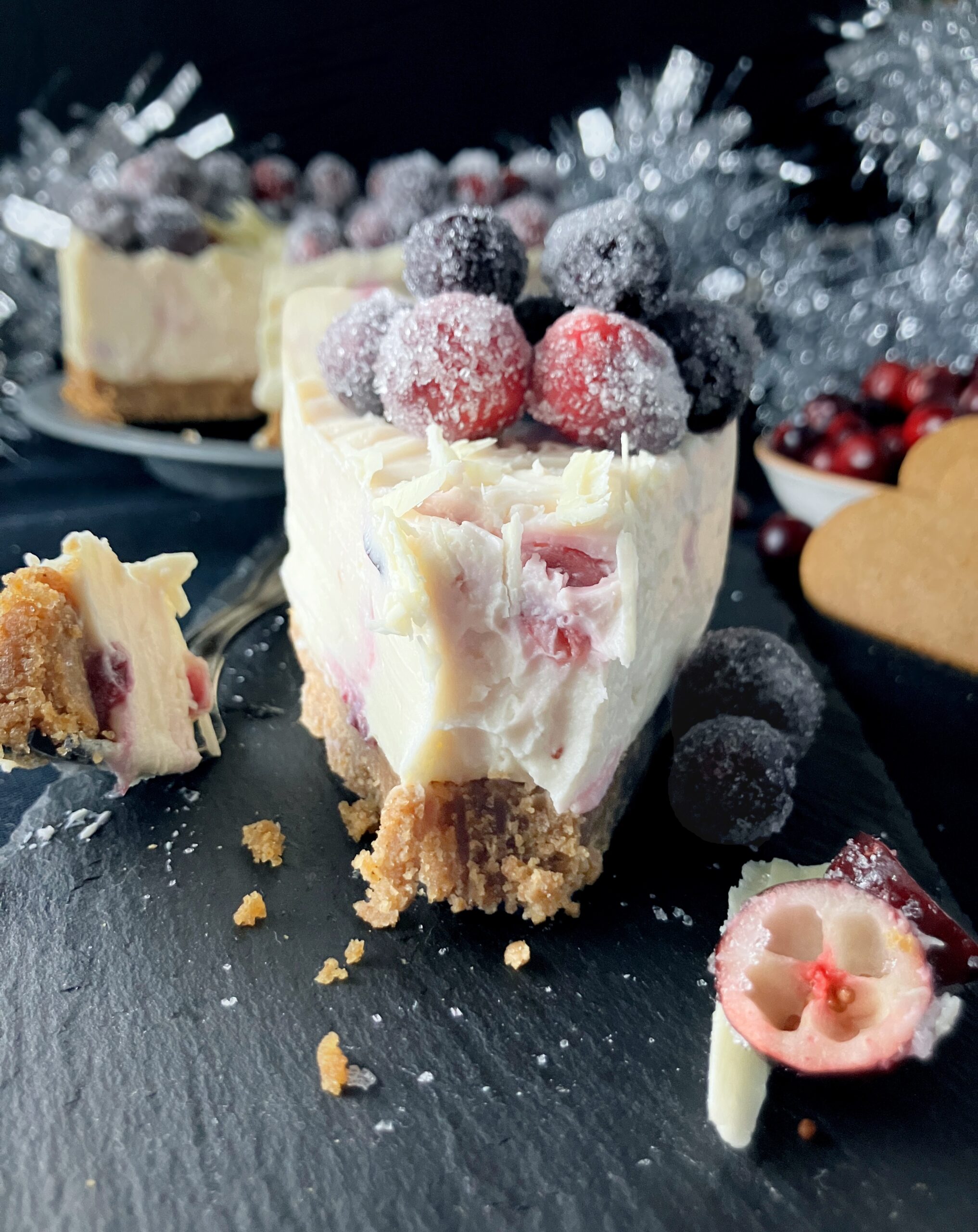 Slice of a mascarpone no bake cheesecake topped with sugar cranberries