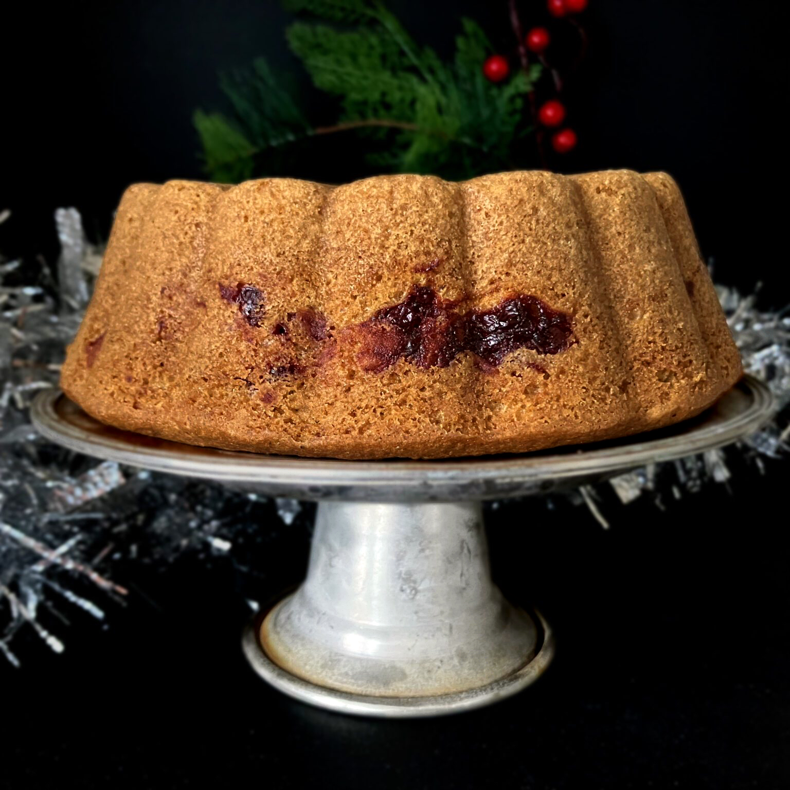 Side view of a festive Swedish soft gingerbread cake (mjuk pepparkaka) topped with lingonberries