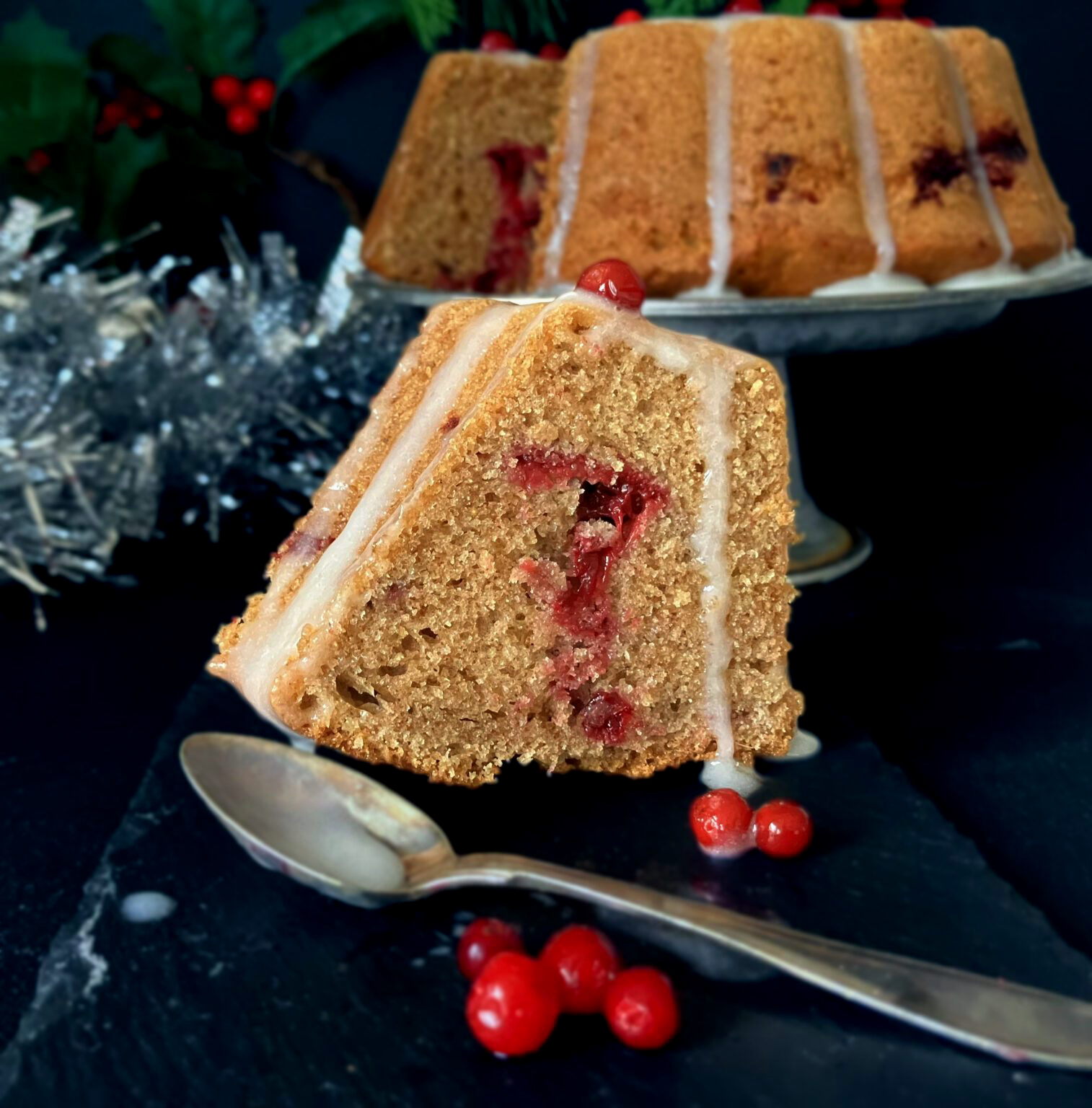 Slice of festive Swedish soft gingerbread cake (mjuk pepparkaka) topped with lingonberries
