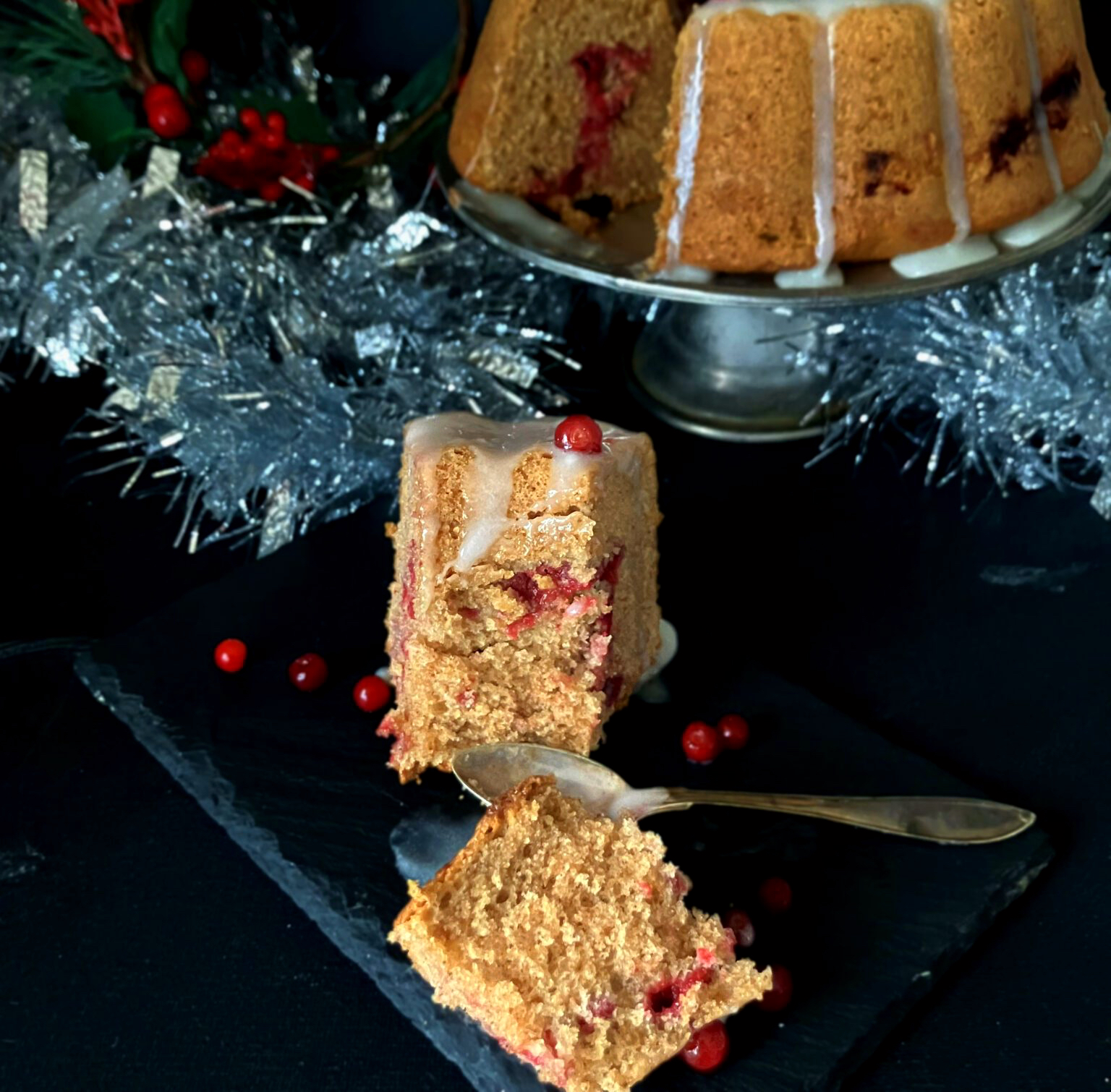 Slice of festive Swedish soft gingerbread cake (mjuk pepparkaka) topped with lingonberries