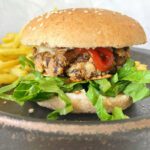 Hearty mushroom burger in a homemade spelt bun, accompanied by golden fries.