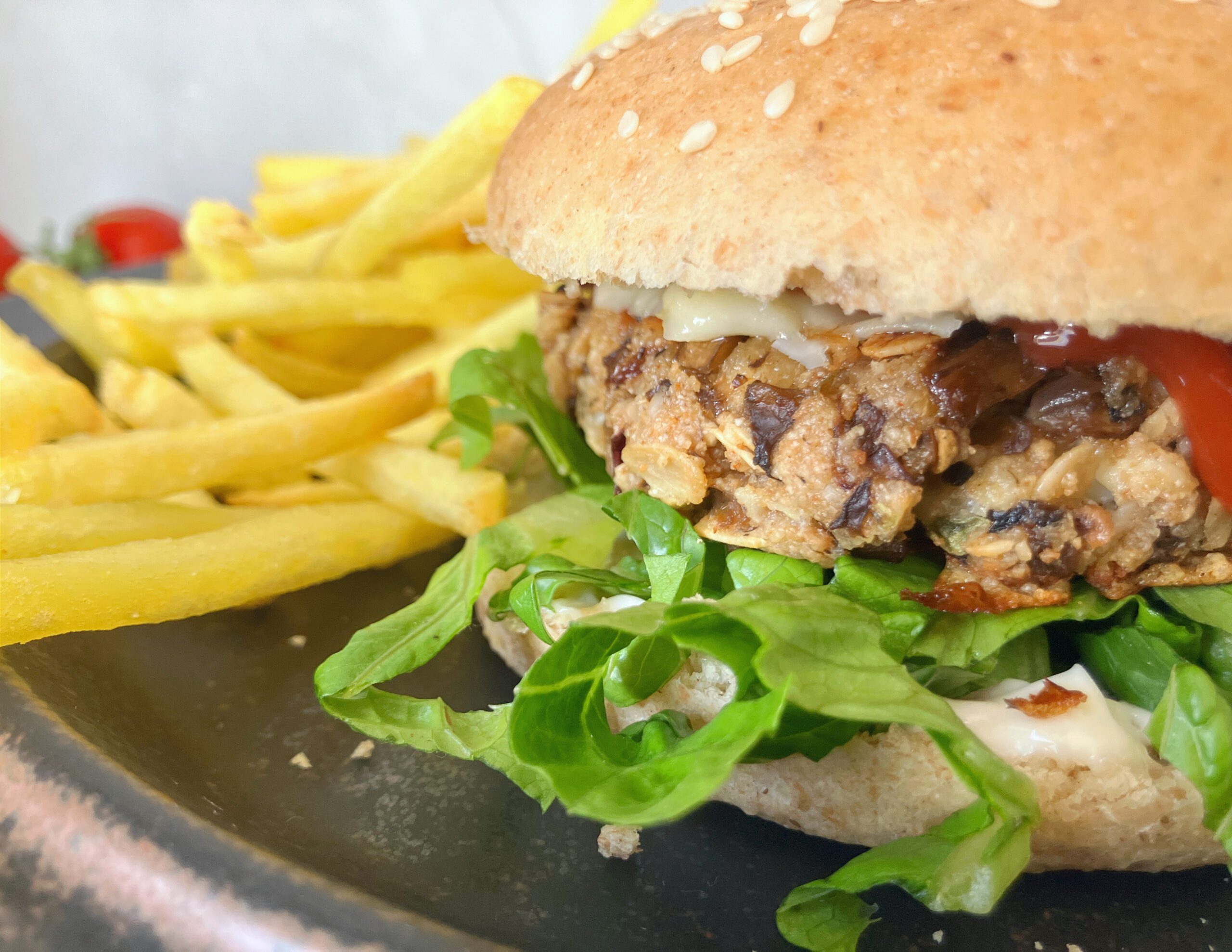 Hearty mushroom burger in a homemade spelt bun, accompanied by golden fries.