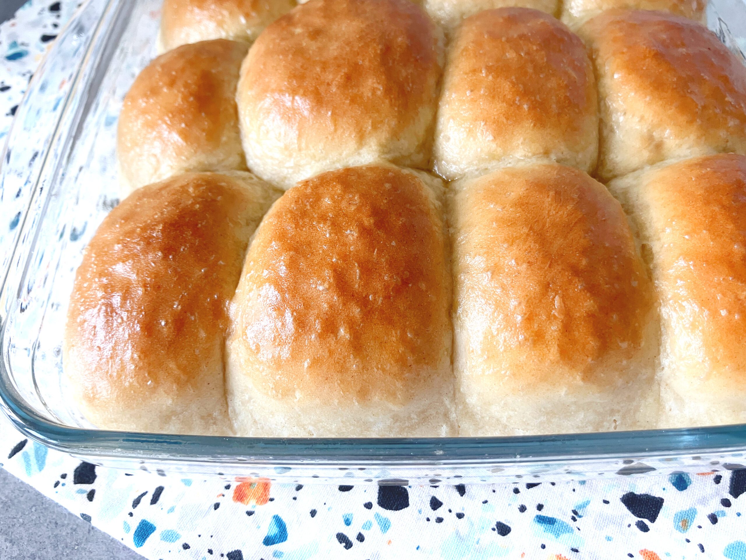 close up shot of spelt flour dinner rolls in a glass dish