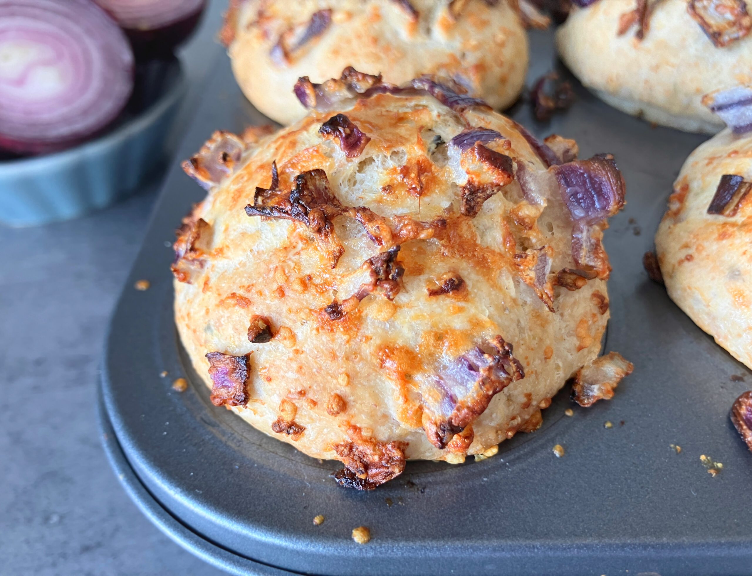 Close up on a wholegrain spelt bun topped with red onion